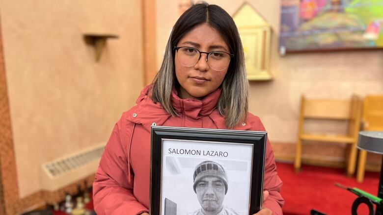 Vianet Lzaro, a young woman from Mexico, poses with a photo of her deceased father Salomon Lzaro. 