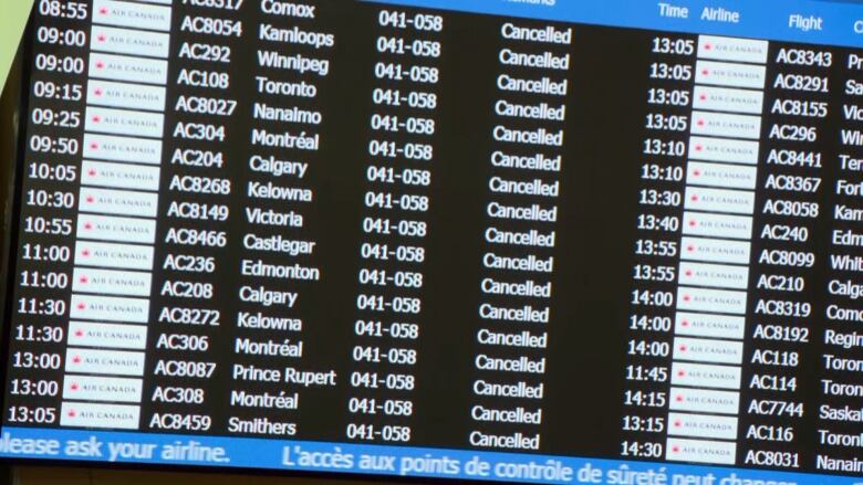 A closeup of a video screen at an airport lists scheduled Air Canada flights, all of which are cancelled.