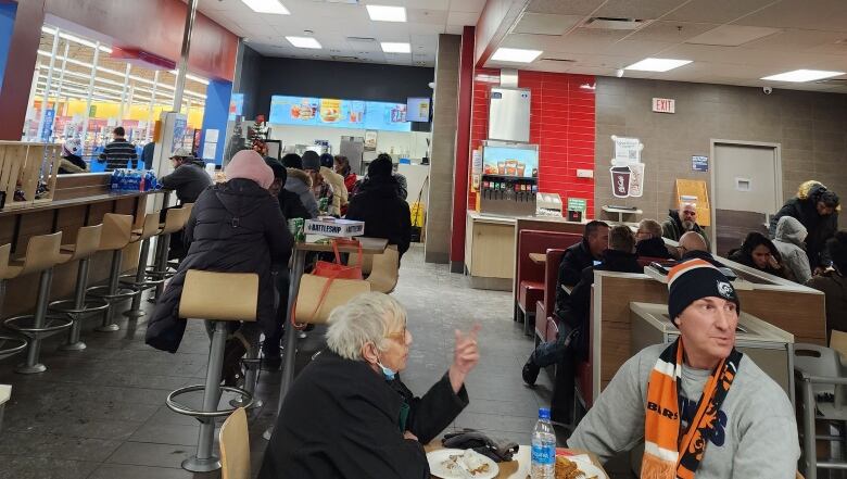 People sitting at tables eating and drinking at a Walmart