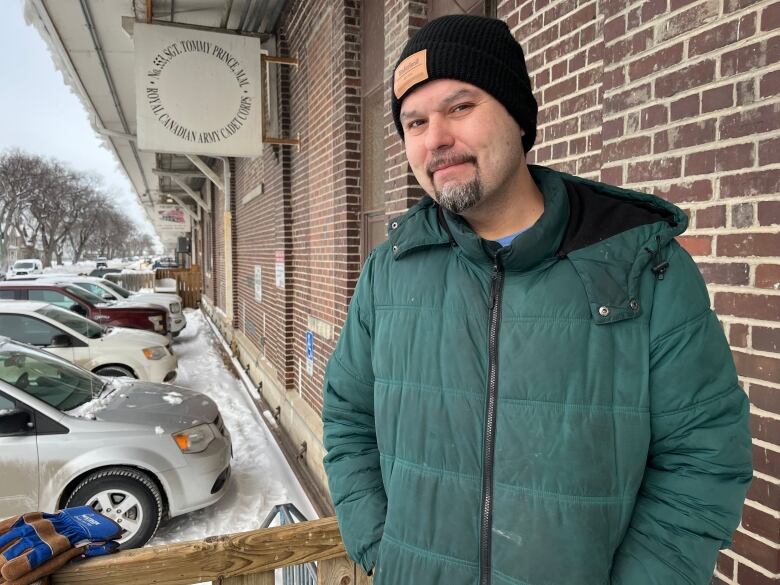 A man in a light winter jacket stands outside the Freight House in Winnipeg.