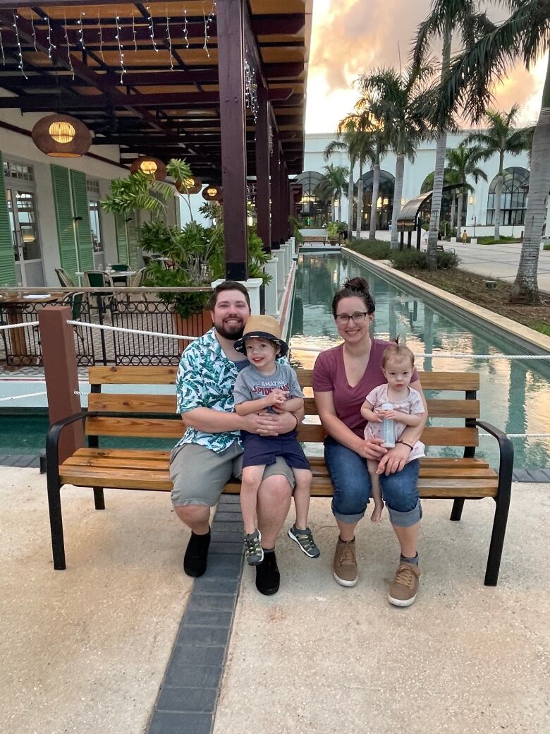 A man and woman sit with their kids.