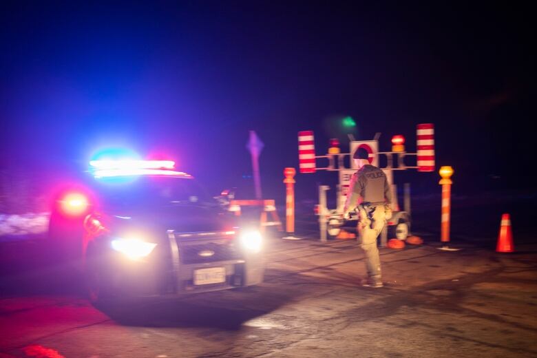 Members of the Ontario Provincial Police close off a section of road near Hagersville, Ont., where an OPP officer was shot and killed on Tuesday, December 27, 2022. 