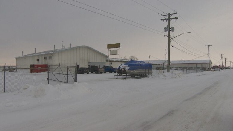 Photo depicts a building along a snow-covered road. 