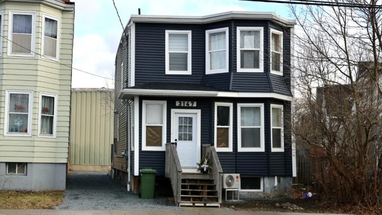 A house on Robie Street where the stabbing is believed to have happened is pictured, with dark siding and light trim. 