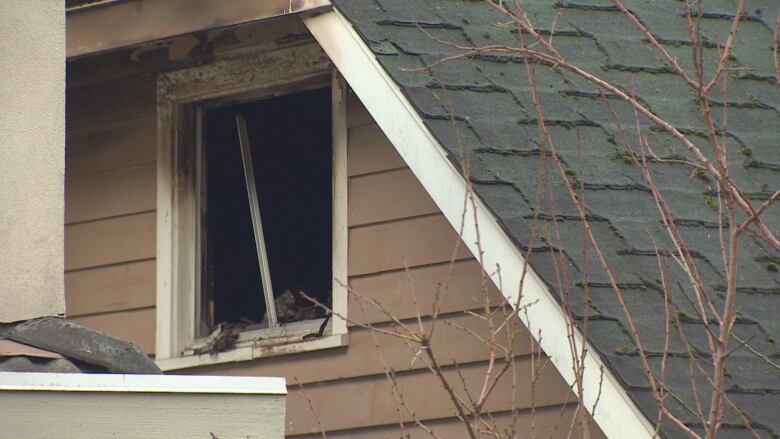 A window on the upper floor of a home is smashed. 