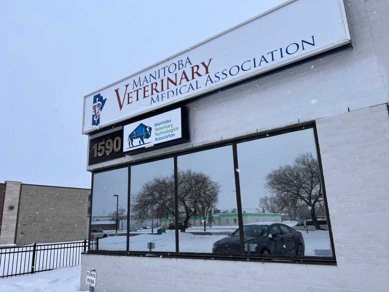 Exterior of a building in snowy weather with a sign that says Manitoba Veterinary Medical Association.