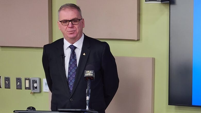 A man stands at a podium and answers questions. 