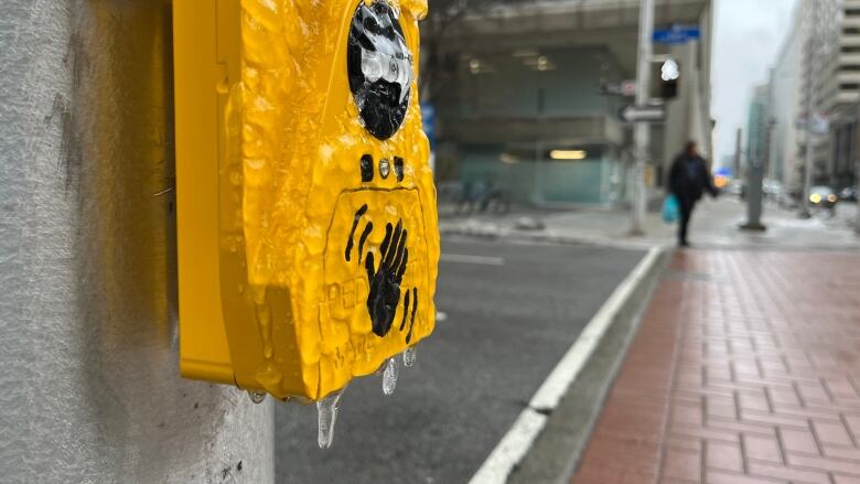 A yellow box at a crosswalk is coated in bumpy ice.