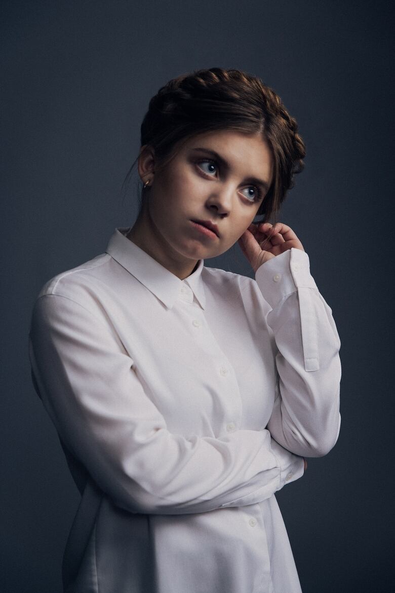 Kate Hallett looking slightly to the side in a white button-down shirt.