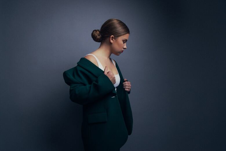 Kate Hallett posing in a dark green blazer.