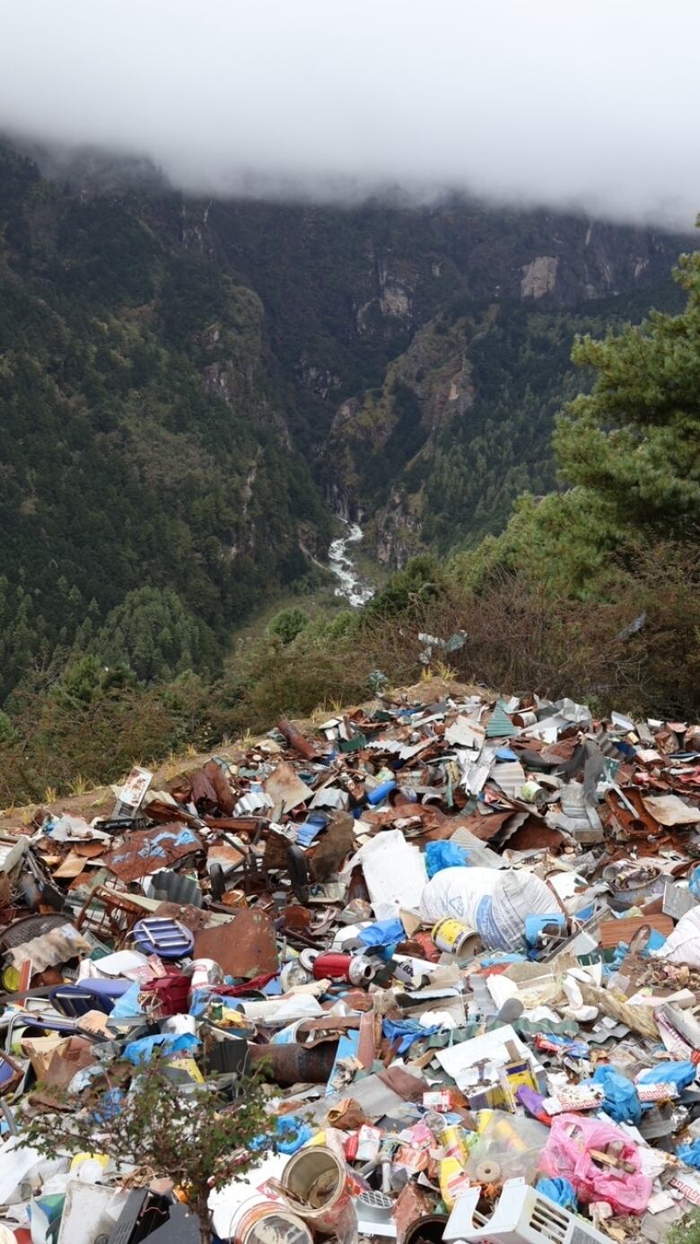 A huge collection of garbage with Nepalese mountains as a backdrop.