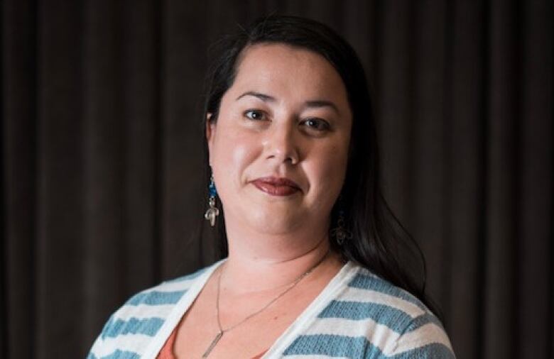 An Indigenous woman sits for a head shot. 