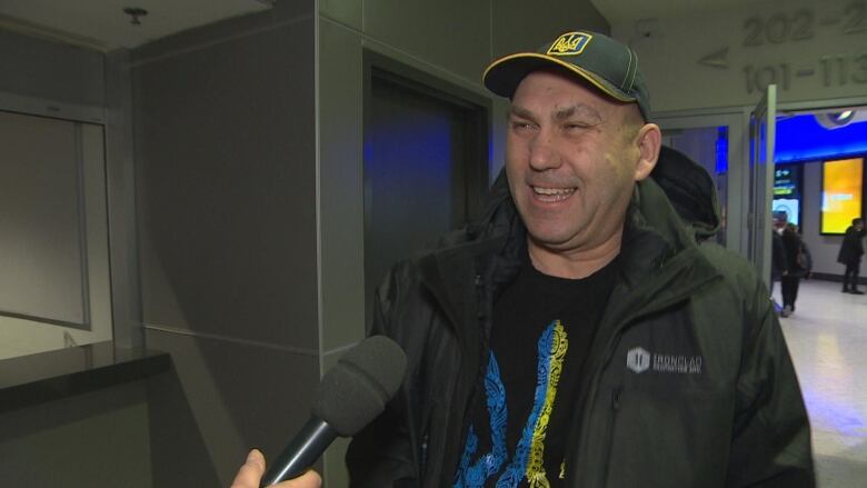 A Ukrainian man in black, yellow and blue clothing prepares to enter the stands at Canada Life Centre in Winnipeg.