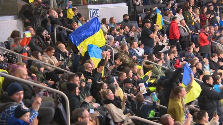 Fans cheer ahead of a hockey game at Canada Life Centre.