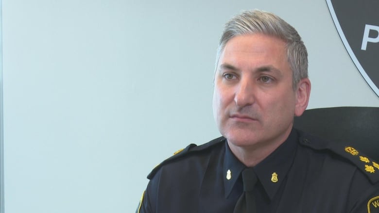 Windsor police chief sits in front of a white wall