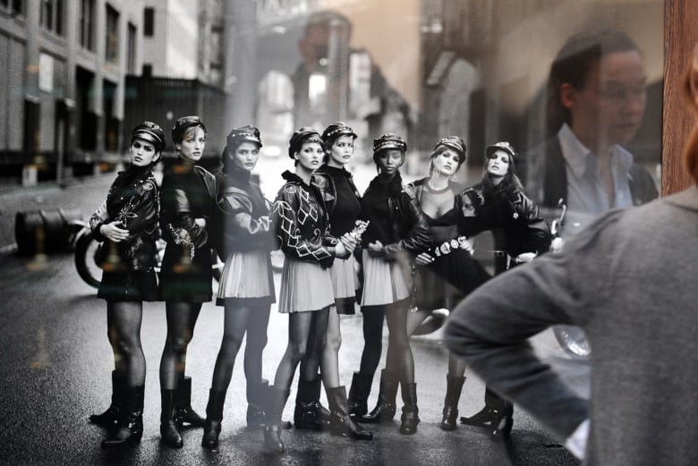 A black and white photo of eight women in skirts and boots.