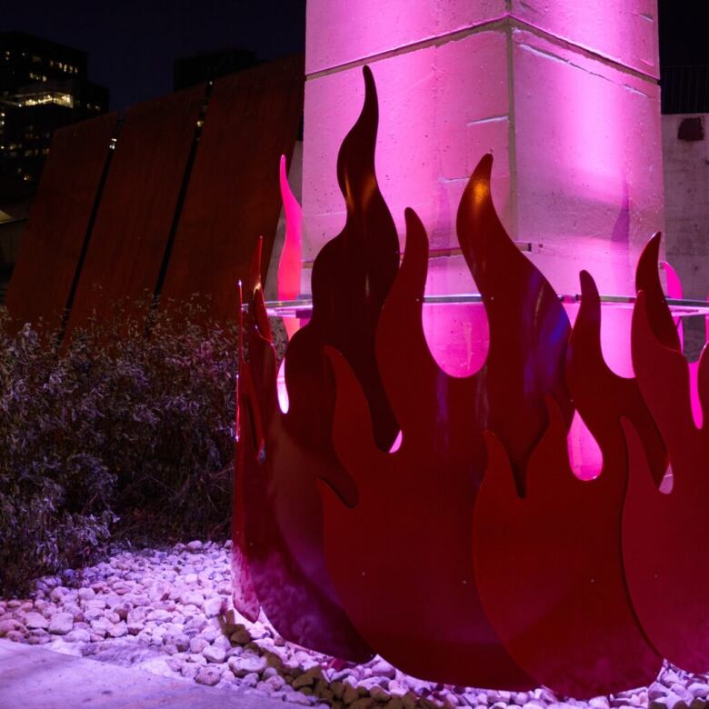 Stylized purple flames and lights are shown at the bottom of a column that supports the Gardiner Expressway, next to the Bentway skating trail.