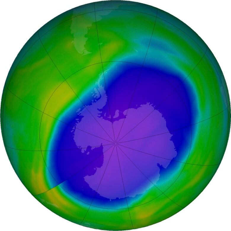 False colour image of the planet earth, with a big blue section showing the ozone layer hole.