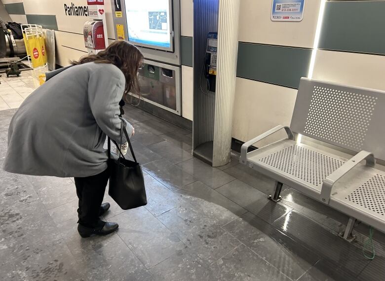 Coun. Marty Carr examines an area where water has was mopped up along the wall on the east-bound platform at Parliament station on Jan. 12, 2023. 