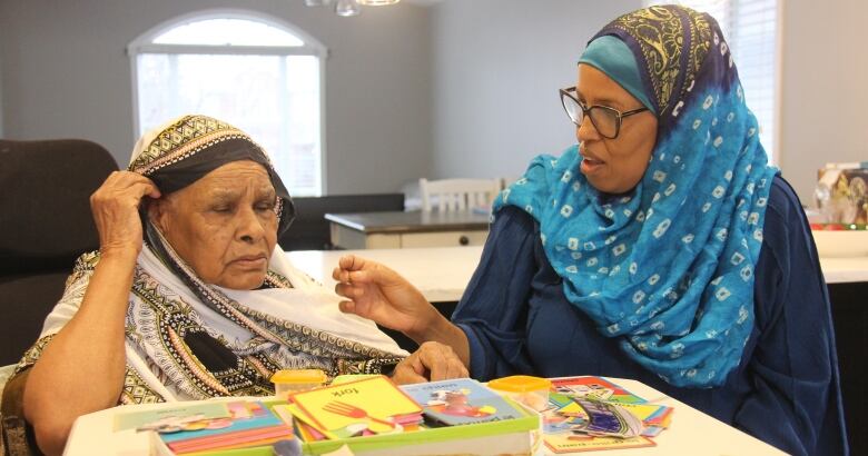 Two women sit at a table.