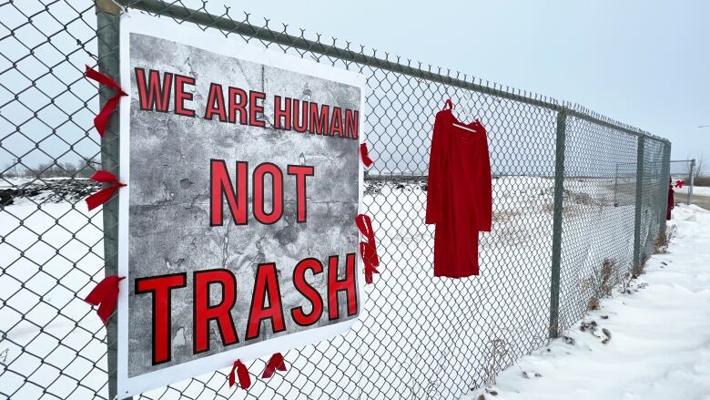 Protesters put up red dresses along the fence of the Brady Road landfill Sunday in honour of missing and murdered Indigenous women and girls.