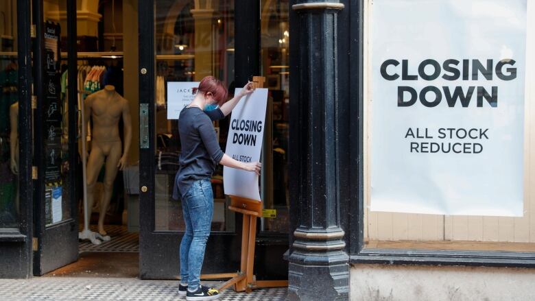 A worker places a closing down sale sign at the entrance to Jack Wills Retail Limited clothing store in Birmingham, U.K., on Monday, April 12, 2021. Non-essential retailers as well as pubs and restaurants with outdoor space will reopen Monday across England after almost 100 days of lockdown, hoping pent-up demand will translate into strong sales. Photographer: Darren Staples/Bloomberg