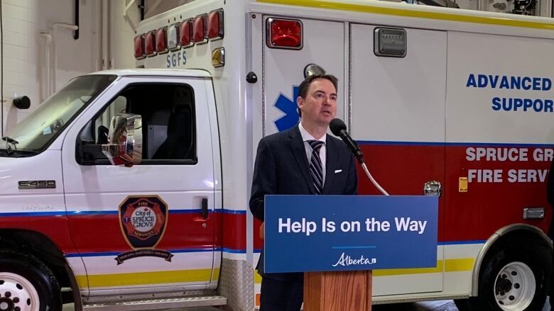 Alberta Health Minister Jason Copping stands in front of a Spruce Grove, Alberta ambulance to announce the release of two new reports. 