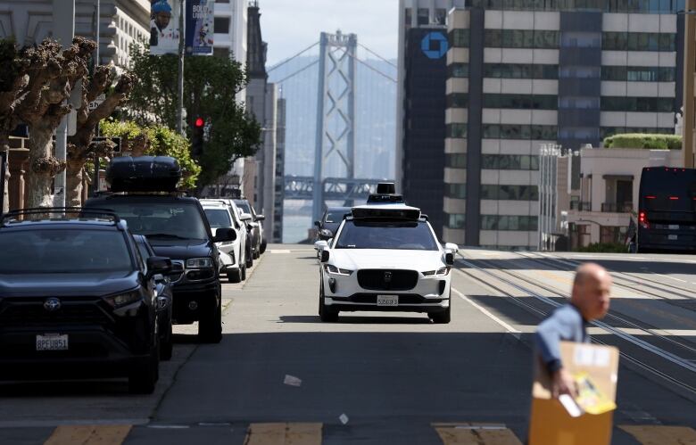 White self-driving car seen on a city street in San Francisco, California.