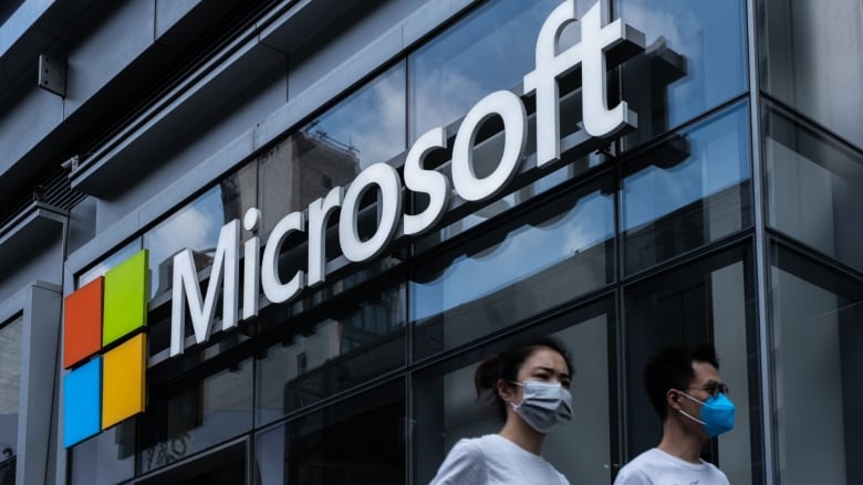 Pedestrians wearing protective masks walk past a Microsoft Technology Center in New York, U.S., on Wednesday, July 22, 2020. Microsoft Corp.is set to post quarterly results after the closing bell and the tech bellwether's performance will likely uphold its standing as a darling of Wall Street. Photographer: Jeenah Moon/Bloomberg