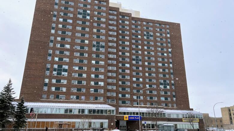 A large brick building stands in the middle of the photo, in brown brick with hundreds of windows.