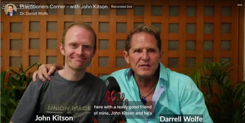 A screenshot of a Youtube video shows Kitson smiling, while Wolfe has his arm around him. The video is called 