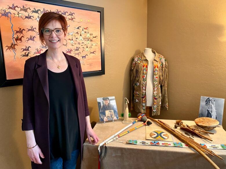 Valerie Guillemin stands next to some of her late father Adrian Paton's collection of First Nations items from southern Saskatchewan. 