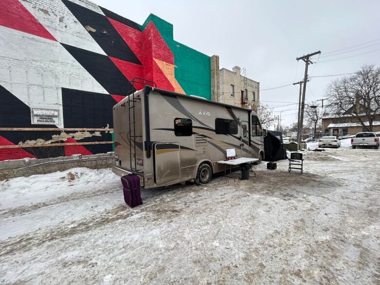 An RV is parked in a snow-covered parking lot.