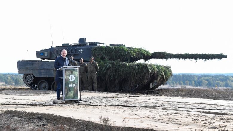 German Chancellor Olaf Scholz delivers a speech in front of a Leopard 2 tank during a visit to a military base of the German army Bundeswehr in Bergen, Germany, October 17, 2022. 