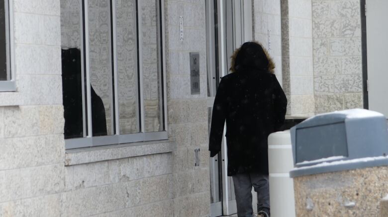 A person stands outside a building.