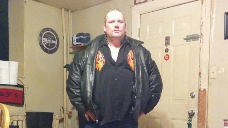 Man in black leather jacket standing with his hands on his hips