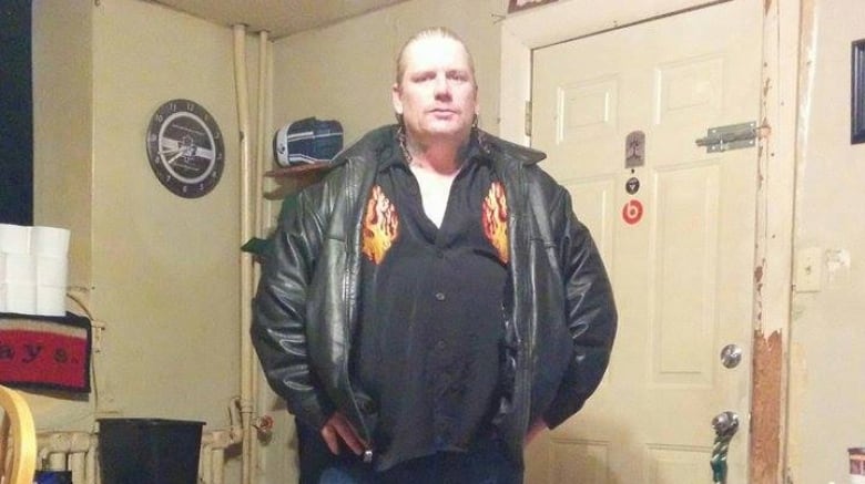 Man in black leather jacket standing with his hands on his hips