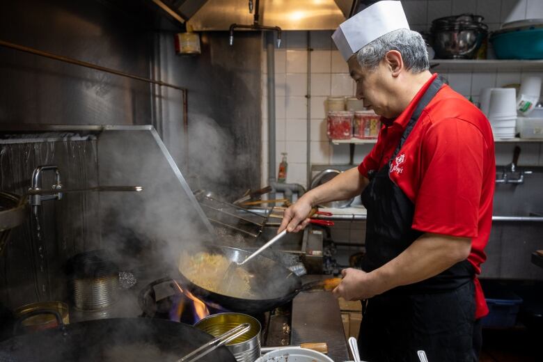 Christopher Wong using his wok to cook.