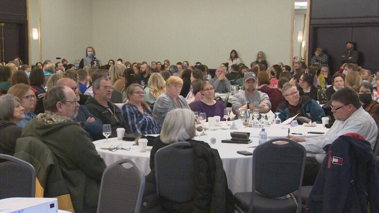 People sit at tables in a large events room.