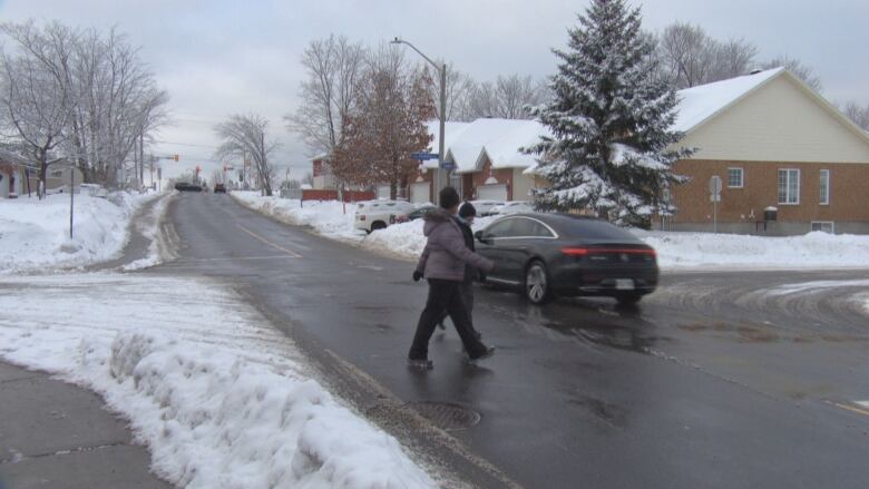 Pedestrians cross Lloydalex Crescent at Echowoods Avenue where many cars ignore four-way stop signs. 