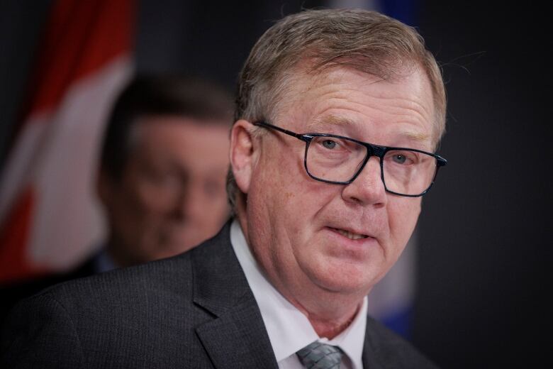 Councillor Gary Crawford speaks while Mayor John Tory looks on during a budget press conference at city hall on Jan. 5, 2023.