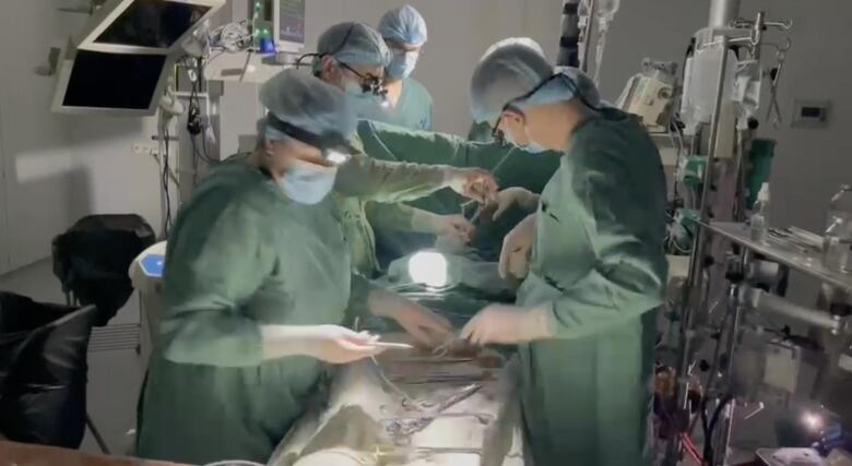 Doctors before surgery during a blackout using headlamps and battery-powered equipment.