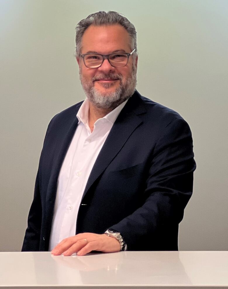 Smiling bearded man in corporate handout photo.