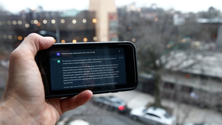 A ChatGPT prompt is shown on a mobile device near a public school in Brooklyn, New York.