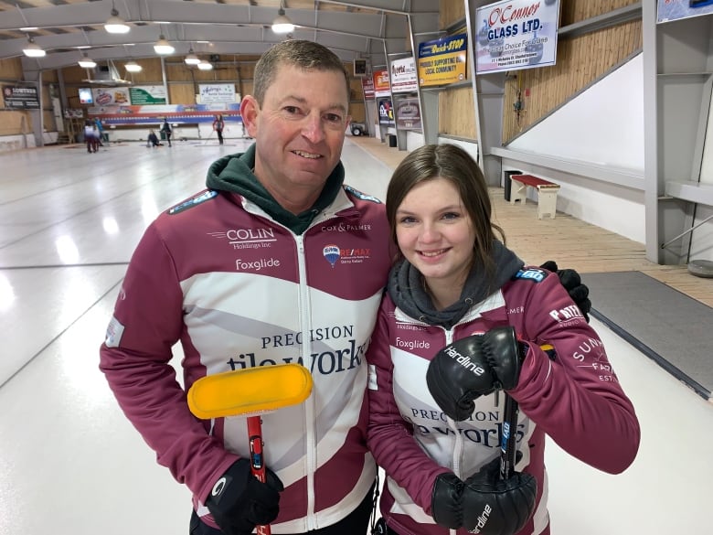 Coach Robbie Lenentine stands on the curling ice with Makiya Noonan.