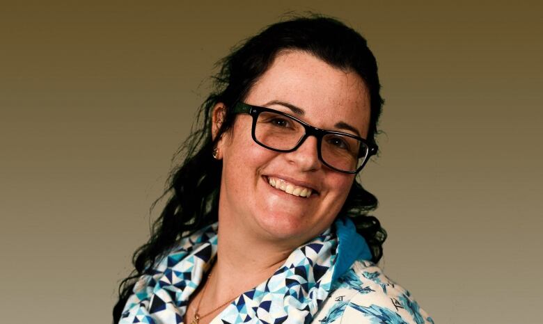 A smiling woman in a blue blouse.