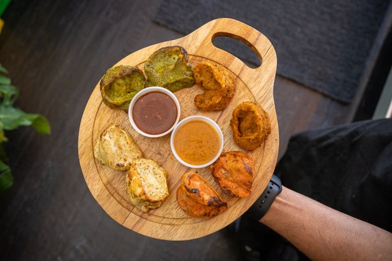 Momo platter > Clockwise top left: Mirchi momo (green), kurkuri momo, tandoori momo, malai momo. Tomato sesame chutney, and spicy chili and garlic chutney (the darker one)