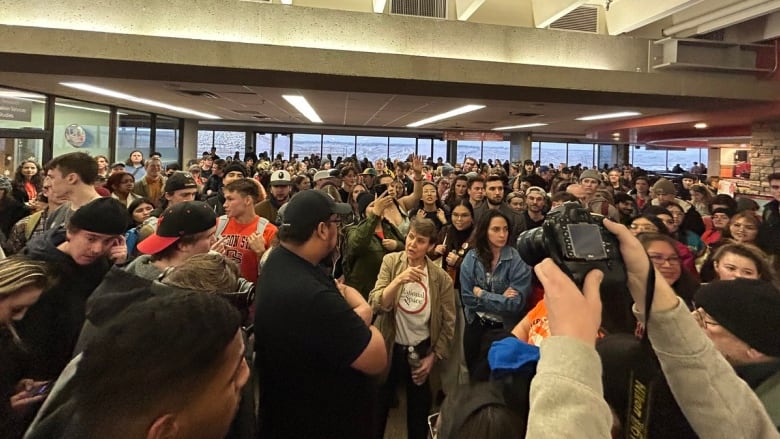 A large crowd of people is pictured in an atrium.