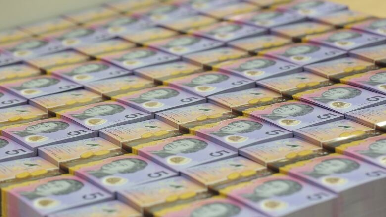 Stacks of Australian $5 banknotes are seen,