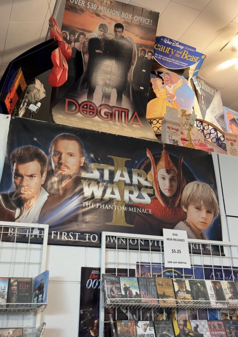 Movie posters and cutouts on top of a ledge in a building.